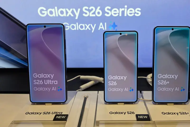 Galaxy S26 Ultra, Galaxy S26 and Galaxy S26+ on store display stands, left to right, each screen and stand label naming the model, under a "Galaxy S26 Series" banner