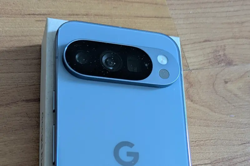 The back of a Google Pixel 10 Pro in Moonstone on a wooden table, showing its camera bar